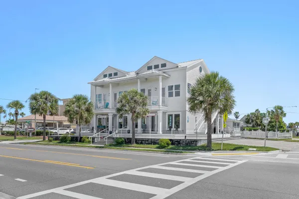 a living room with furniture a flat screen tv and kitchen view