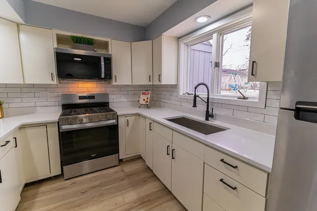 a kitchen with stainless steel appliances a stove sink and microwave