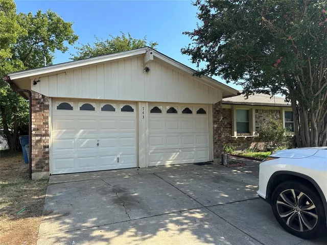 a front view of a house with a garden and parking space