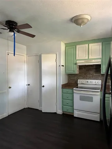 a kitchen with a refrigerator and a stove top oven
