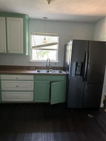 a kitchen with a refrigerator and a sink