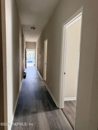 a view of a hallway with wooden floor