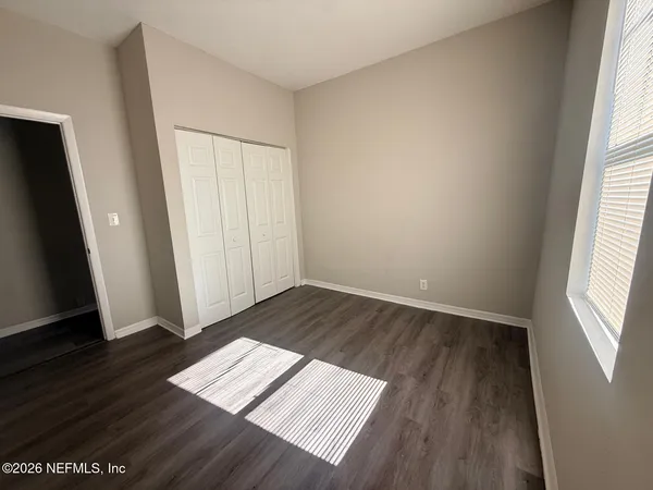 an empty room with wooden floor and window