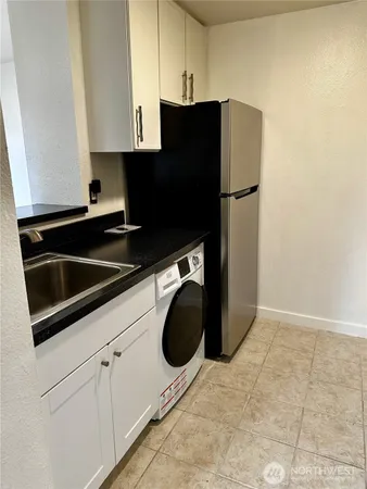 a kitchen with white cabinets and black appliances