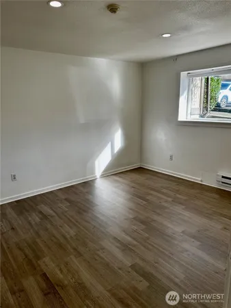 a view of an empty room with wooden floor