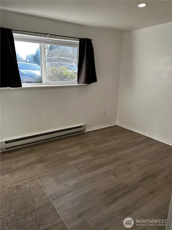 a view of an empty room with wooden floor