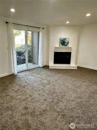 a view of an empty room with a fireplace and a window