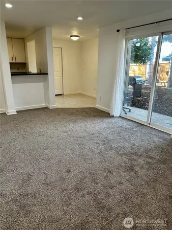 a view of an empty room with a fireplace and a window