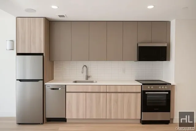 a kitchen with a sink a refrigerator and cabinets