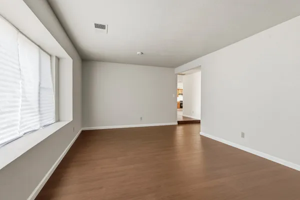 wooden floor in an empty room with a window