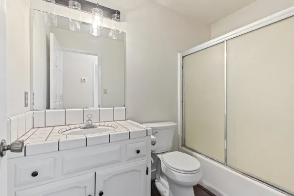 a bathroom with a sink a toilet and a mirror