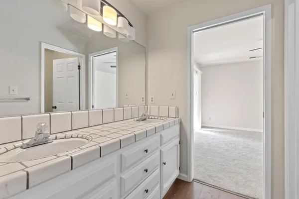 a bathroom with a granite countertop sink and a mirror