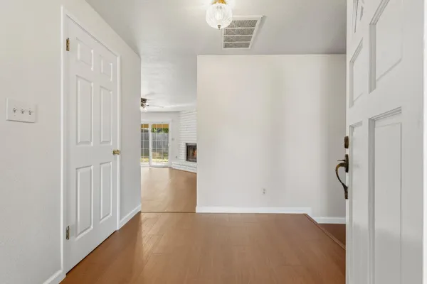 a view of a hallway with wooden floor and entryway