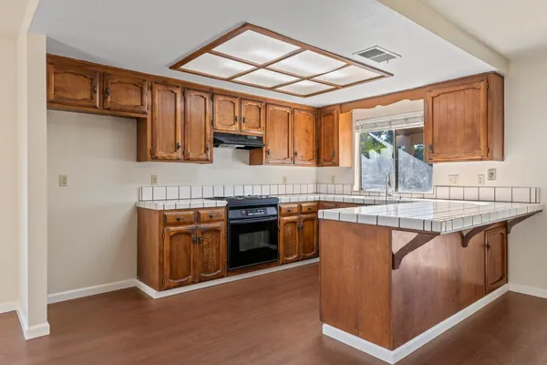 a kitchen with stainless steel appliances granite countertop a stove a sink and a microwave