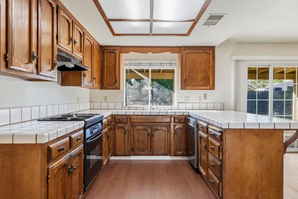 a kitchen with stainless steel appliances granite countertop a stove a sink and a microwave