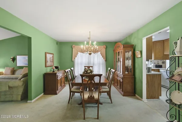 a kitchen with a dining table chairs and white cabinets