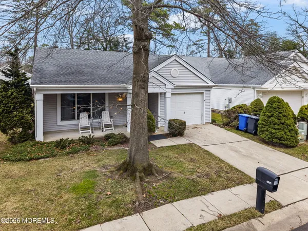 a view of a house with backyard and a tree