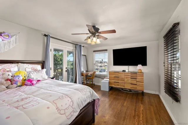 a bedroom with bed tv and view of living room