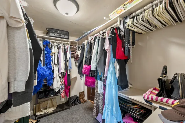 a view of walk in closet with clothes and shoes