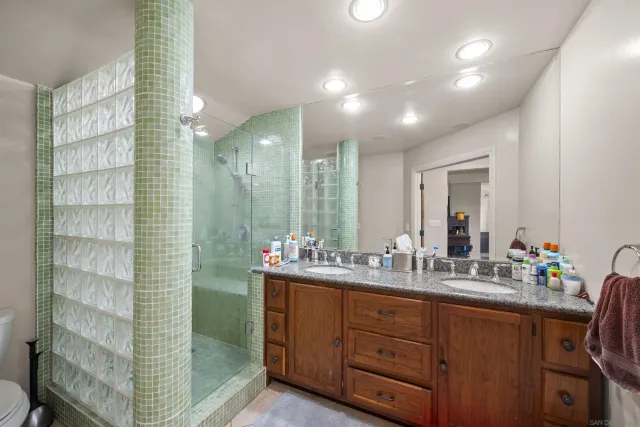 a bathroom with double vanity and a shower