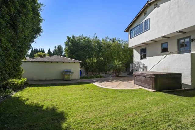 a view of a house with backyard and sitting area