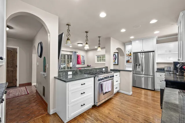 a kitchen with stainless steel appliances kitchen island granite countertop a refrigerator and a stove