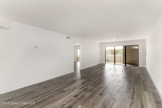 a view of an empty room and wooden floor
