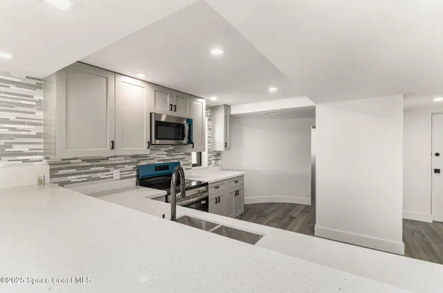 a view of kitchen with sink microwave and refrigerator