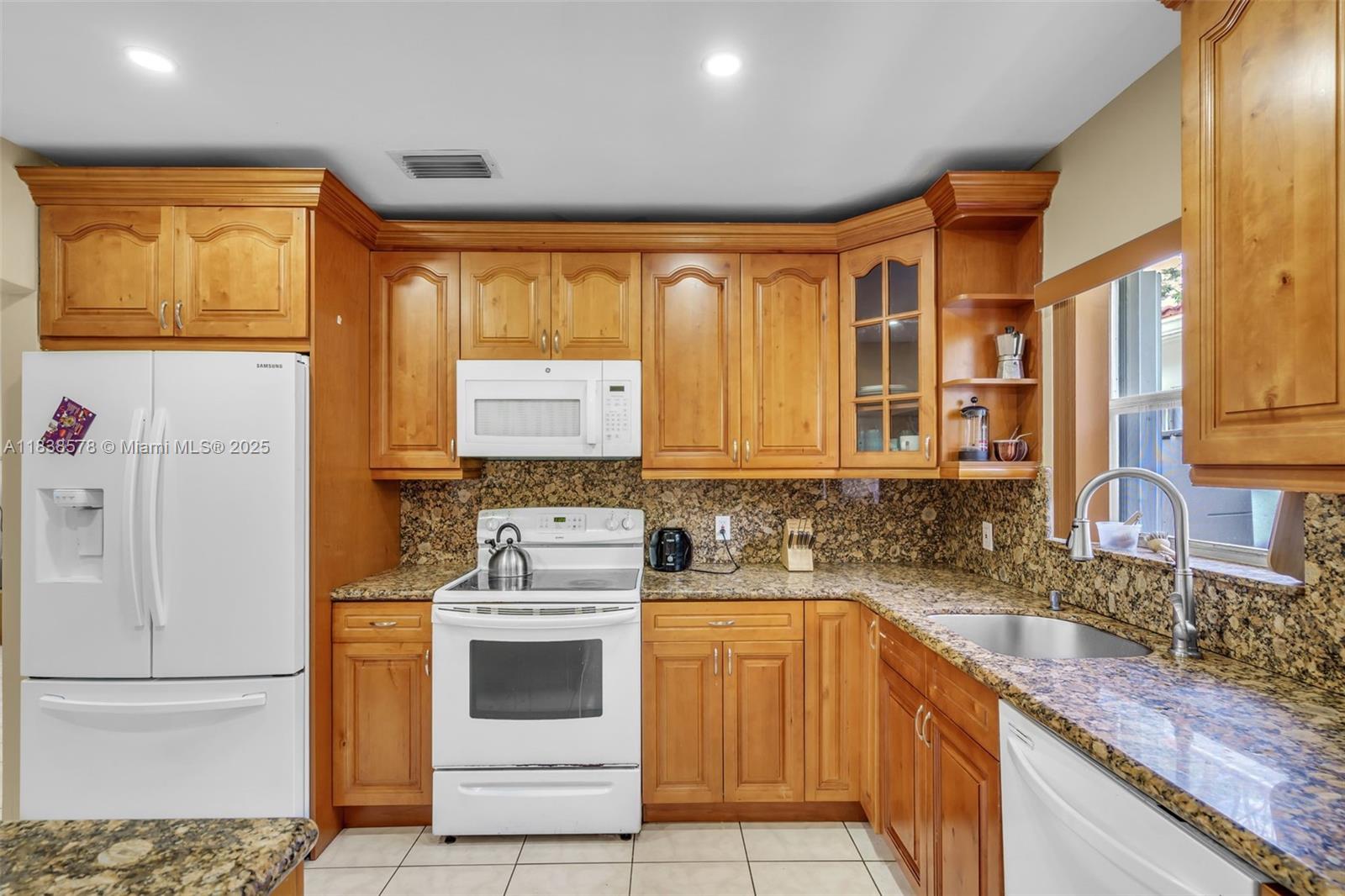 2761 Southwest 33rd Court Miami, FL 33133 - Photo 10 of 46 a kitchen with a stove a sink and a refrigerator