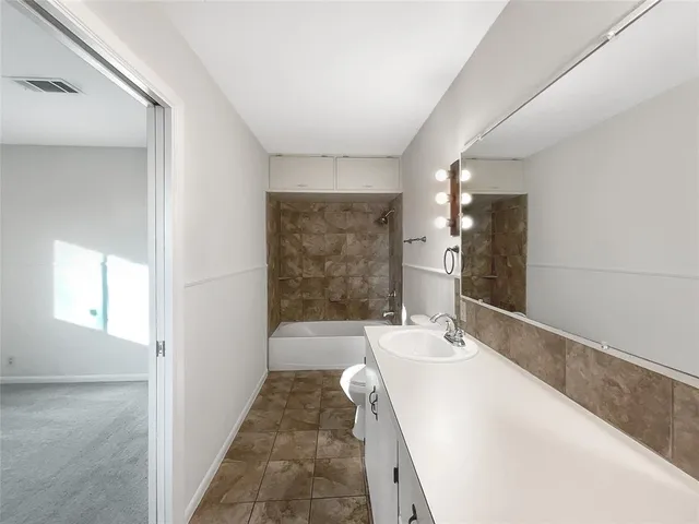 a en suite bathroom with a sink and a large mirror