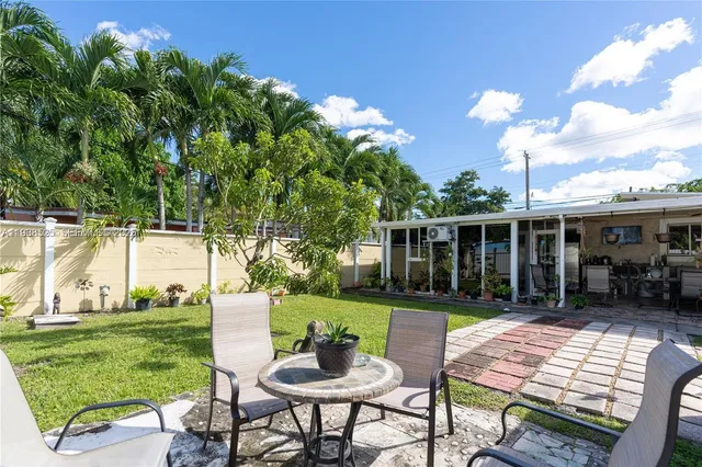a view of a house with backyard sitting area and garden