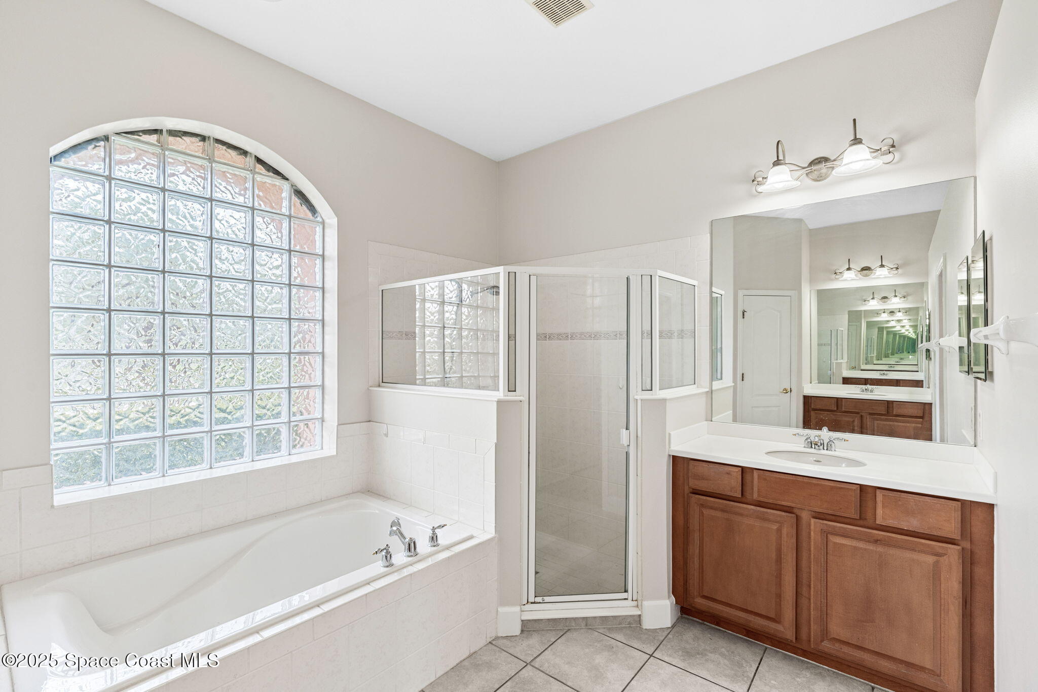 3121 Camberly Circle Melbourne, FL 32940 - Photo 21 of 52 a bathroom with a tub sink and mirror
