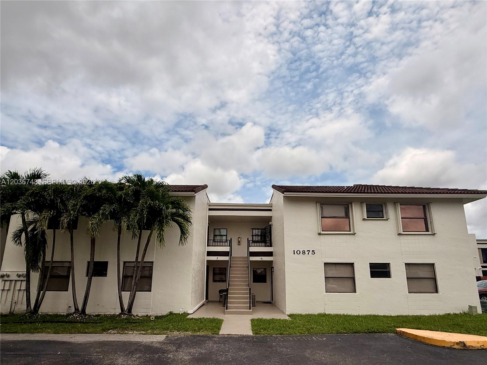 10875 Northwest 7th Street, Unit 1136 Miami, FL 33172 - Photo 2 of 25 a front view of a house with a yard and garage