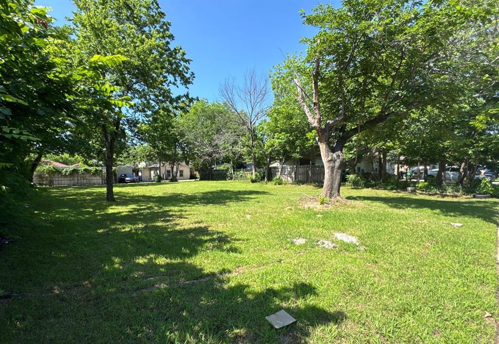 7242 Amy Street Dallas, TX 75217 - Photo 1 of 4 Expansive green space featuring established trees and a clear, level surface