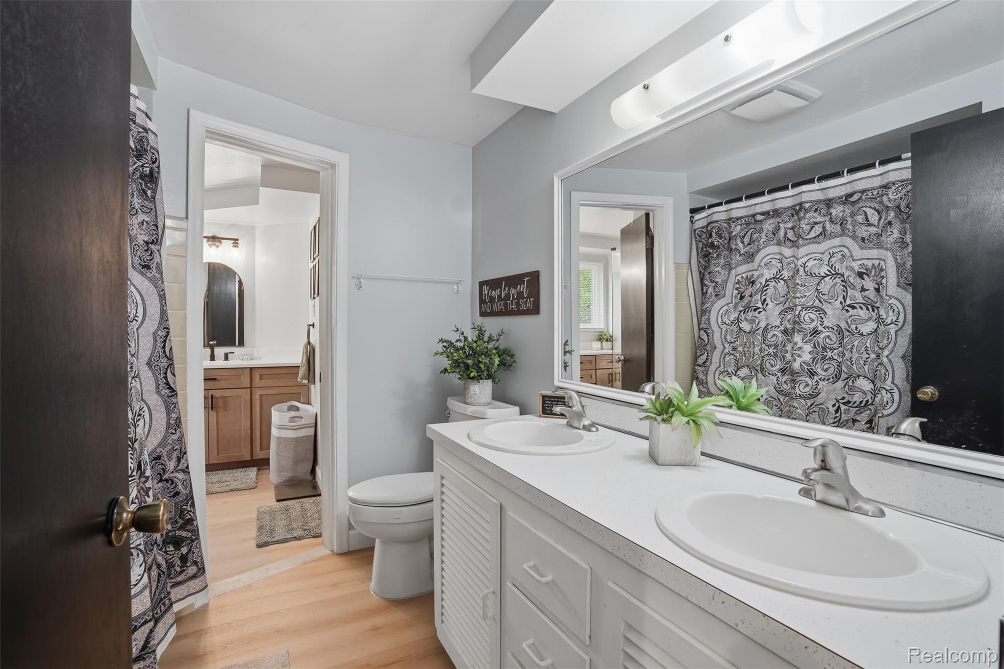 47129 Dunsany Road Northville, MI 48167 - Photo 27 of 49 Full bath featuring double vanity, light wood-style floors, and curtained shower