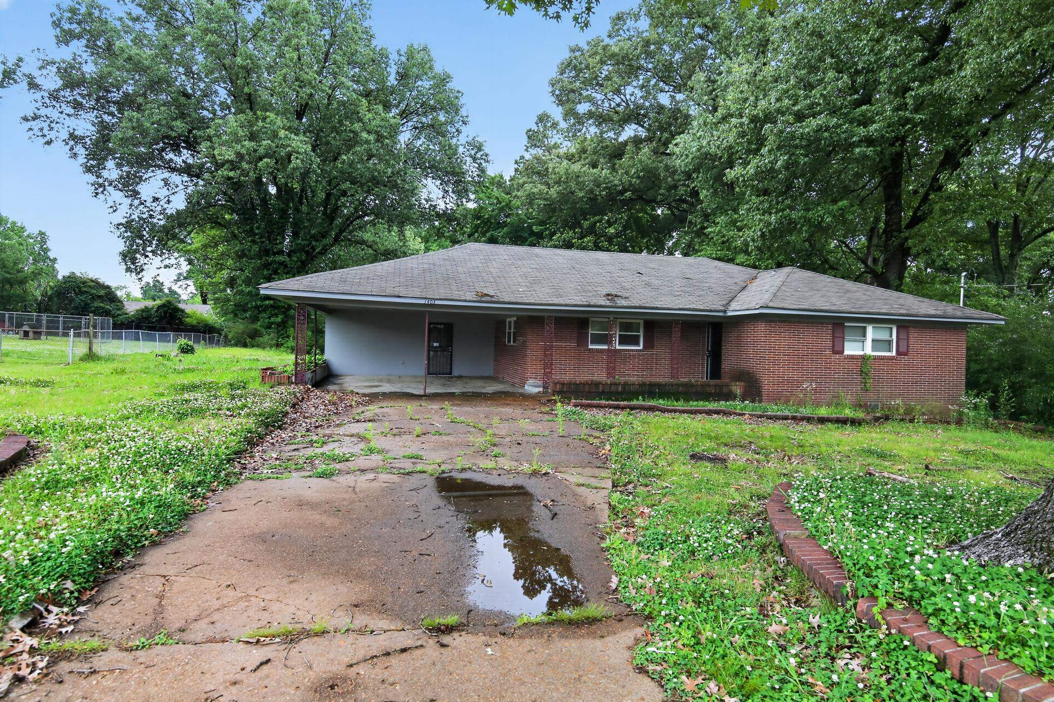 1403 Old Hickory Road Memphis, TN 38116 - Photo 2 of 31 Brick exterior featuring a covered carport, multiple windows with shutters, and a sloped roof