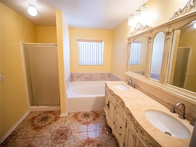 a bathroom with a tub sink and mirror