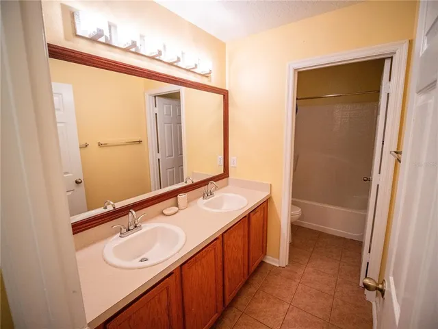a bathroom with a double vanity sink and a mirror