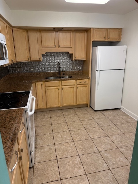 2234 South Goebbert Road, Unit 122 Arlington Heights, IL 60005 - Photo 13 of 29 a kitchen with a refrigerator a stove top oven a sink and cabinets