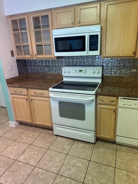 2234 South Goebbert Road, Unit 122 Arlington Heights, IL 60005 - Photo 14 of 29 a kitchen with granite countertop a stove top oven microwave and cabinets
