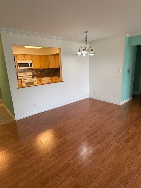2234 South Goebbert Road, Unit 122 Arlington Heights, IL 60005 - Photo 16 of 29 an empty room with wooden floor chandelier fan and windows