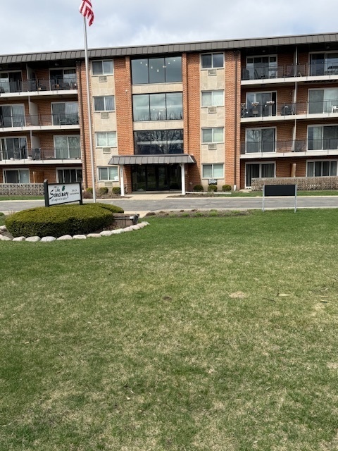 2234 South Goebbert Road, Unit 122 Arlington Heights, IL 60005 - Photo 4 of 29 a front view of a house with a yard