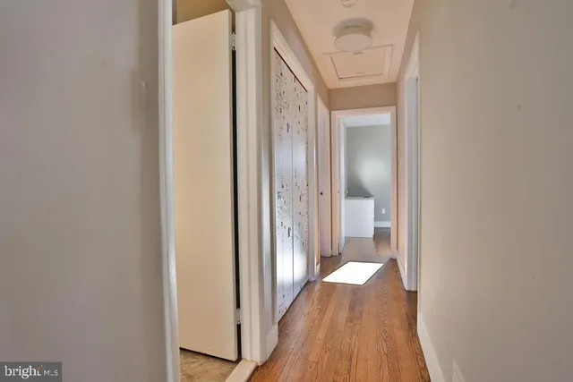 a view of a hallway with wooden floor