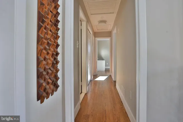 a view of a hallway with wooden floor and staircase