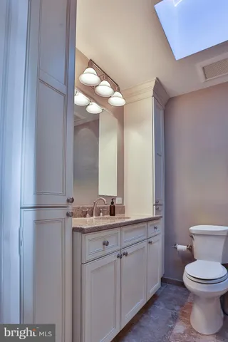 a bathroom with a toilet sink and mirror