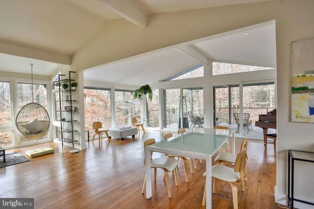 a living room with furniture a floor to ceiling window and wooden floor