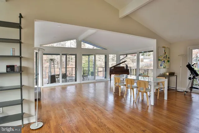 a view of a dining room with furniture floor to ceiling window and wooden floor