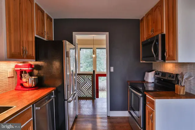 a kitchen with a refrigerator and a stove top oven
