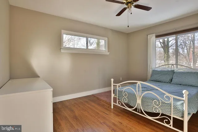 a utility room with a window a ceiling fan and wooden floor