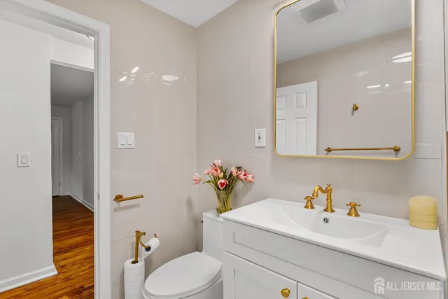 a bathroom with a sink vanity mirror and toilet